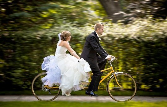 Фото свадебной фотосессии на велосипеде за городом.