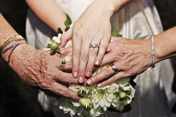 Сентиментальные фотоидеи для родителей на свадьбе. Фотография, на которой засняты руки невесты, ее мамы и бабушки с обручальными кольцами.